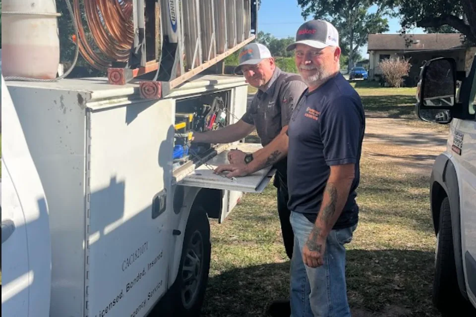 Two Parkersons Heating and Air technicians working at the company service truck